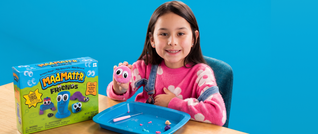 Child creating a character with Mad Mattr Friends sensory dough and googly eyes on a white surface