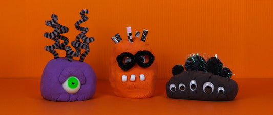 Child and adult playing with Mad Mattr Monster Class creations — colorful Halloween monsters made from soft sensory dough